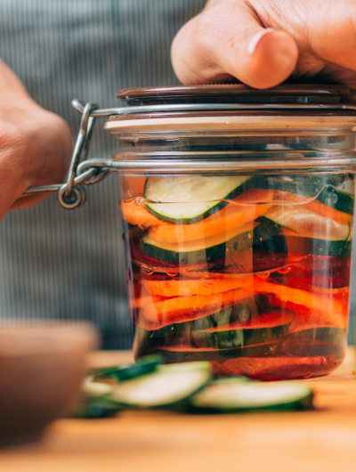 Vegetable fermentation. Woman holding jar with fermented vegetables.