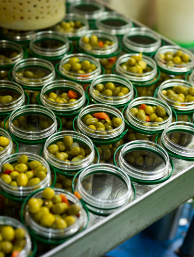 Open glass jars with olives - preparation for canning. High quality photo